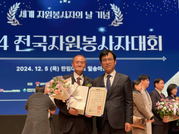 지난해 12월 세계 자원봉사자의 날을 맞아 이강건 수원금빛봉사회장이 대통령 표창을 받은 뒤 기념사진을 촬영하는 모습. 본인 제공