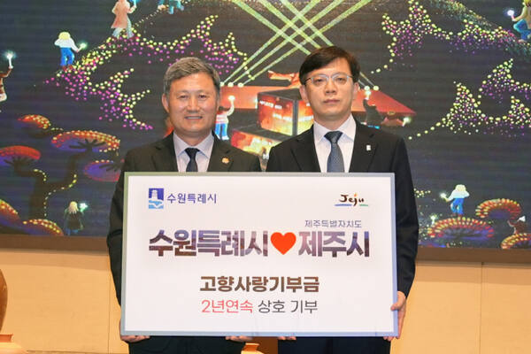 현근택 수원시 제2부시장(오른쪽)이 지난 15일 제주시 메종글래드호텔 컨벤션홀에서 김완근 제주시장과 고향사랑 상호 기부식을 열고 기념촬영을 하고 있다. 수원시 제공