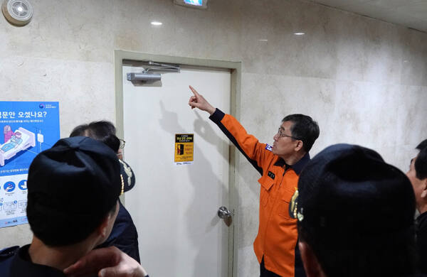 21일 오전 용인 처인구 김량장동의 한 건물에서 안기승 용인소방서장이 ‘방화문 닫기 홍보스티커’를 배부하고 부착하는 시범을 보이고 있다. 용인소방서 제공
