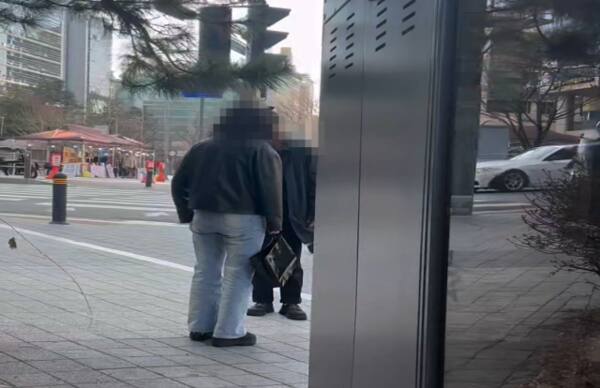 보이스피싱조직 1차 현금수거책이 서울 구로구 구로동 길에서 현금을 교부 받고 있다. 평택경찰서 제공
