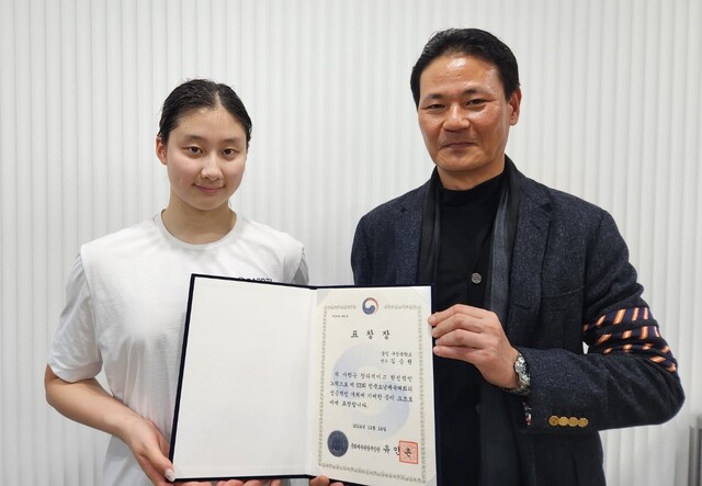 김범준 경기도수영연맹 회장(오른쪽)이 수영 유망주 김승원(구성중)에게 유인촌 문화체육관광부장관 표창장을 전수하고 있다.경기도수영연맹 제공
