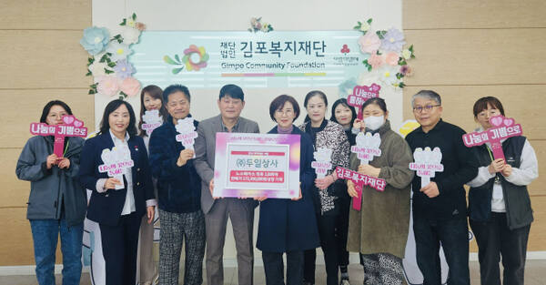정홍주 두일상사 대표(왼쪽 네번째)와 조선희 김포복지재단 대표이사 등 관계자들이 의류를 기탁식에서 기념사진을 촬영하고 있다. 김포시 제공