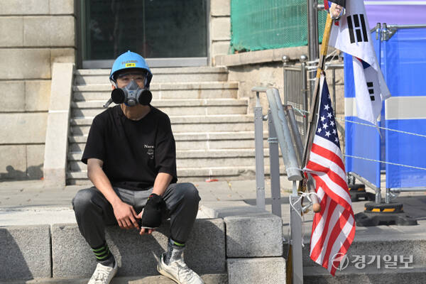 헌법재판소의 윤석열 대통령 탄핵심판 선고일인 4일, 서울 안국역 인근 거리에서 방독면을 착용한 시민이 앉아 있었다. 방독면을 쓴 이유를 묻자, 그는 "만에 하나"라고 짧게 답했다.조주현기자