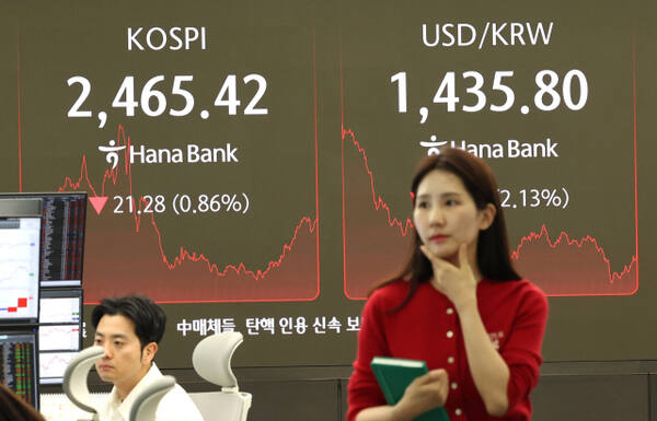 4일 서울 중구 하나은행 딜링룸에서 한 딜러가 자료를 살피고 있다. 이날 코스피는 전장보다 21.28포인트(0.86%) 내린 2,465.42에 장을 마감했다. 원/달러 환율은 32.9원 내린 1,434.1원. 연합뉴스
