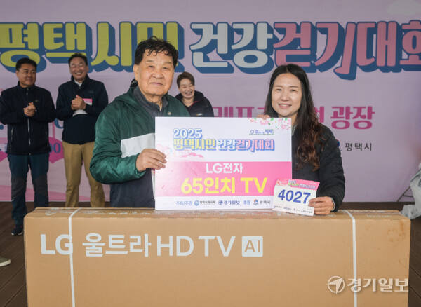 신항철 경기일보 대표이사 회장이 1등 경품인 65인치 TV를 추첨 후 기념촬영을 하고 있다.