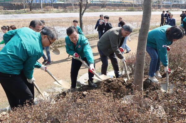 김성제 의왕시장과 공무원들이 7일 식목일을 기념해 월암동 왕송호수공원에 느티나무를 심고 있다. 의왕시 제공