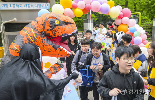 어린이날을 사흘 앞둔 1일 오전 수원특례시 장안구 대평초등학교에서 학생들이 학부모들이 준비한 간식을 받고 있다. 윤원규기자