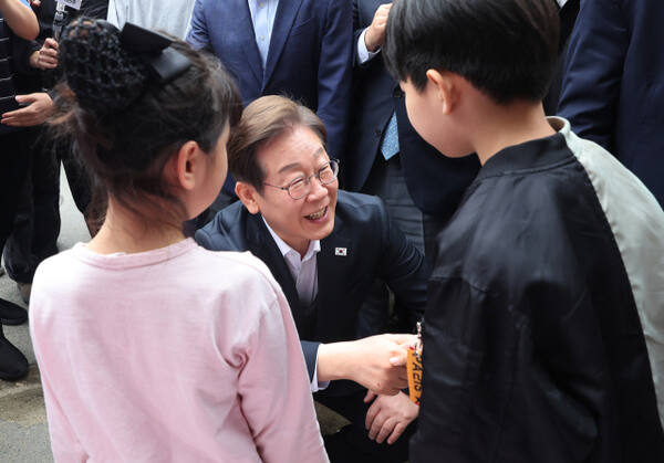 더불어민주당 이재명 대선 후보가 5일 경기도 양평군 양평물맑은시장에서 열린 ‘골목골목 경청투어’에서 어린이들과 대화하고 있다. 연합뉴스