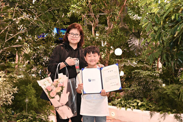 정태운 군과 정군의 어머니가 모범 어린이 표창장을 들고 환하게 웃고 있다.부천시 제공.