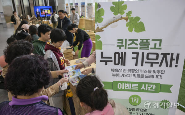 시민들이 누에 키우기 키트를 받고 있다.