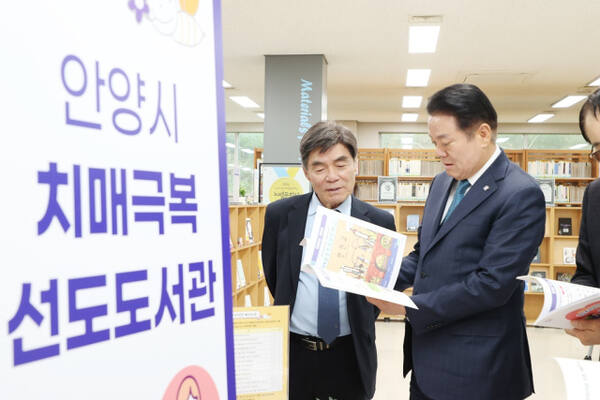 최대호 안양시장이 최근 안양시 만안구 만안동 만안도서관에서 열린 ‘치매극복 선도도서관 지정 현판식’에서 도서를 살펴 보고 있다. 안양시 제공