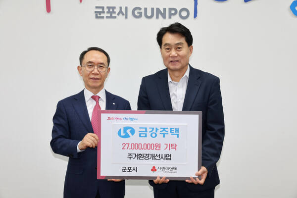 ㈜금강주택 최상순 대표가 하은호 군포시장에게 취약계층 주거환경개선사업 후 이를 기탁하고 있다.군포시 제공