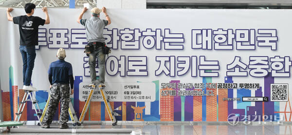 21대 대통령선거 사전투표를 앞둔 27일 인천공항 1터미널 출국장에 인천선관위 관계자들이 사전투표소에 대형 안내 홍보물을 붙이고 있다. 조병석기자