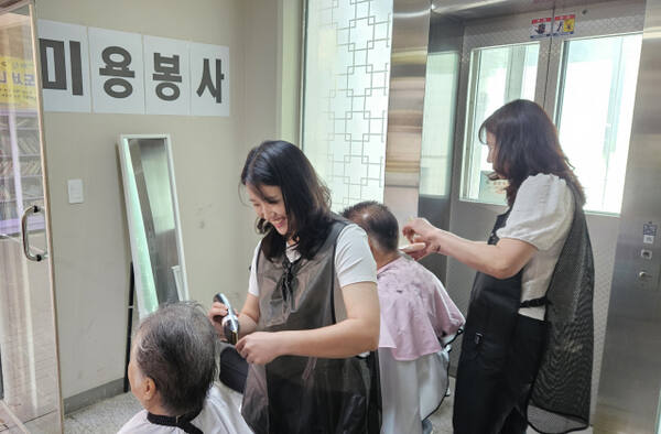 27일 오전 하늘마을 경로잔치에서 퀸헤어 자원봉사단이 어르신에게 이발서비스를 제공하고 있다.
