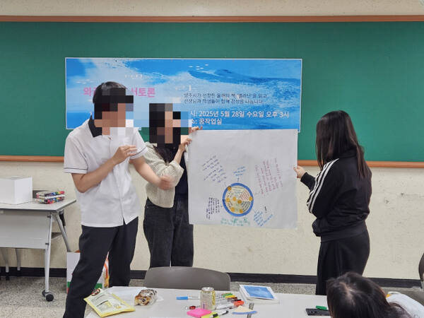 지도교사와 학생들이 자신들이 읽고 느낀 점을 적은 글을 설명하고 있다. 덕계고 제공