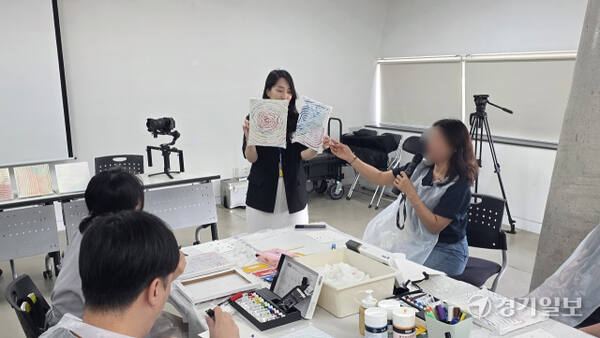 이날 프로그램을 이끈 박다은 홍익대 교육대학원 미술치료 강사(우측 상단)가 참가자의 작품을 들고, 참가자는 자신의 그림에 대해 설명하고 있다. 이나경기자