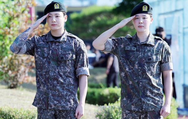 육군 현역 복무를 마친 그룹 BTS의 지민(오)과 정국(왼)이 11일 오전 경기도 연천군 연천공설운동장에서 거수경례로 전역을 알리고 있다. 연합뉴스