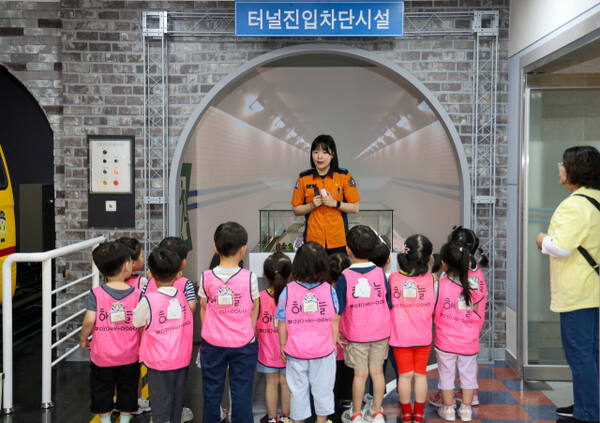 의왕소방서 백운119안전센터 2층 안전체험관에 밀폐된 터널에서 화재가 발생했을 때 어떻게 행동해야 하는지 미니어처 모형을 통해 이해하고 직접 체험할 수 있게 구성된 ‘터널 화재 시뮬레이션’체험이 설치돼 있다. 사진은 어린이들이 터널진입차단시설에서 소방대원의 설명을 듣고 있는 모습. 의왕소방서 제공