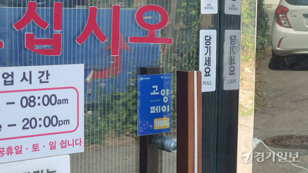 고양특례시 덕양구 주교동에 위치한 한 식당 출입문에 고양페이 가맹점 스티커가 부착돼 있다. 신진욱기자