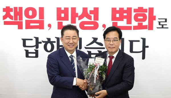 더불어민주당 김병기 당 대표 직무대행 겸 원내대표(왼쪽)가 17일 국회에서 국민의힘 송언석 원내대표를 예방해 축하난을 전달하고 있다. 연합뉴스