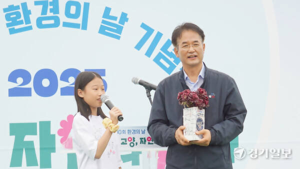 지난 21일 고양특례시 덕양구 행주동 소재 고양한강평화공원에서 열린 제30회 환경의 날 기념식에서 정발초 5학년 임예서 양이 이동환 시장에게 재활용 플라스틱으로 만든 장미꽃 화분을 선물하고 있다. 신진욱기자