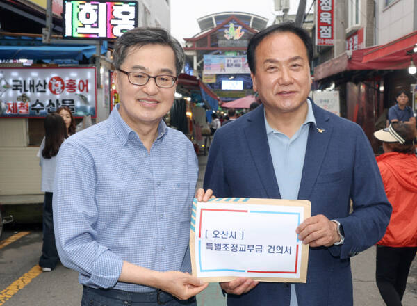이권재 오산시장(오론쪽)이 지난 21일 오산 오색세장에서 열린 ‘경기살리기 통 큰 세일’ 개막식에서 김동연 경기도지사에게 특별조정교부금 지원을 요청하고 기념촬영을 하고 있다. 오산시 제공