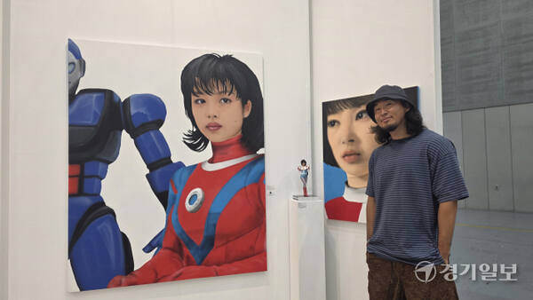 ‘갤러리박영’의 피 킴(김태기 작가)이 자신의 피규어 및 회화 작품 앞에서 포즈를 선보이고 있다. 이나경기자