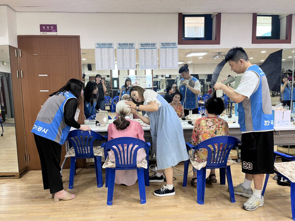 한국가스공사 인천기지본부 임직원들이 장수 사진을 촬영하는 어르신들의 머리 손질을 돕고 있다. 한국가스공사 인천기지본부 제공