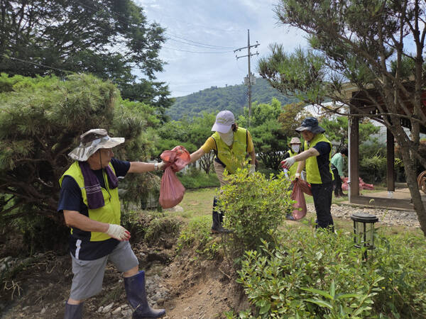 군포시의회 김귀근 의장이 동료 시의원, 직원들과 중복인 30일 가평군 상면 수해 지역에서 복구작업을 하고 있다. 군포시의회 제공