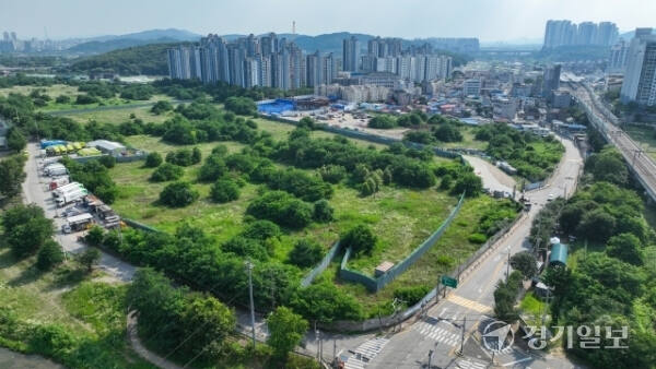 남양주시 퇴계원리 133번지 일원 군 유휴지와 유휴지 뒤편이 신도시로 개발되고 있는 모습. 윤원규기자