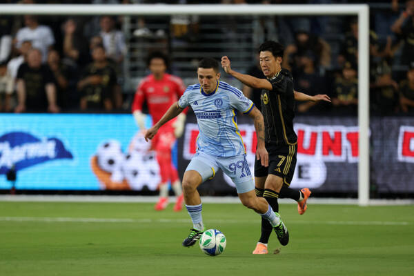 Oct 5, 2025; Los Angeles, California, USA; Atlanta United FC midfielder Bartosz Slisz (99) controls the ball past LAFC forward Son Heung-Min (7) during the first half at BMO Stadium. Mandatory Credit: Kiyoshi Mio-Imagn Images