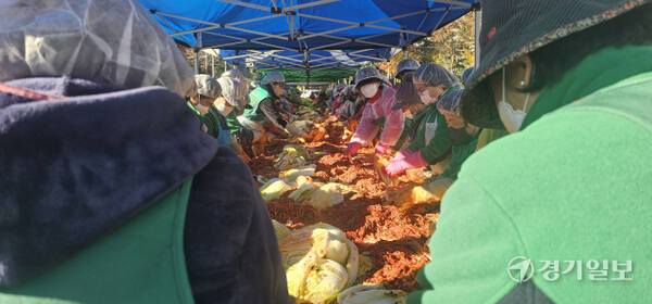 21일 오전 평택시 새마을운동협의회가 시청 별관 주차장에서 열린 2025 사랑의 김장 나누기 행사에서 회원 및 봉사자들이 김장 김치를 담그고 있다. 윤동현기자