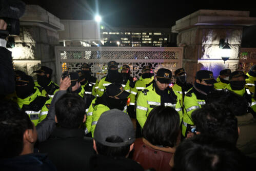 지난해 12월3일 비상계엄이 선포된 밤 여의도 국회 정문을 경찰이 지키고 서 있는 모습. 경기일보DB