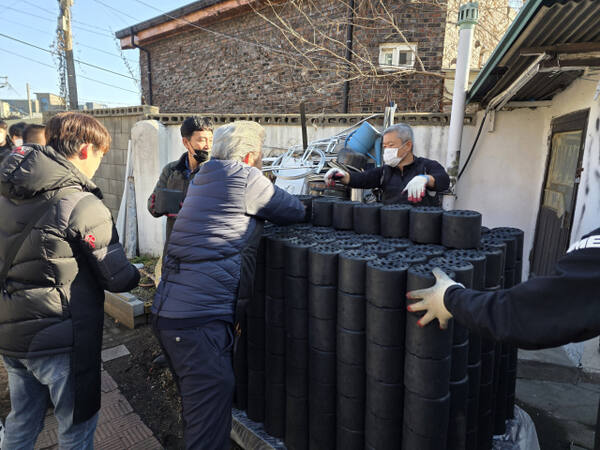 성남시내버스㈜ 임직원들이 성남 고등동 일대에서 취약계층에 연탄을 배달하고 있는 모습. 성남시자원봉사센터 제공