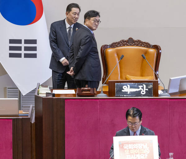 우원식 국회의장과 더불어민주당 김병기 원내대표가 11일 국회에서 열린 12월 임시국회 1차 본회의에서 국민의힘 곽규택 의원이 형사소송법 일부개정법률안에 대한 무제한 토론(필리버스터)에 손팻말을 이용하는 것에 대해 의견을 나누고 있다. 연합뉴스