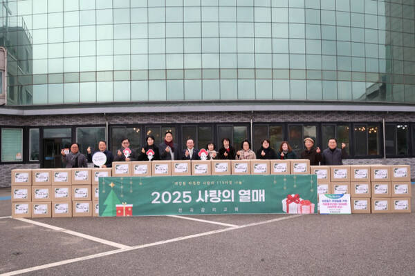 전곡감리교회가 ‘2025 사랑의 열매’로 성탄절 소외된 이웃에게 식료품 꾸러미 100세트를 전달하고 기념촬영을 하고 있다. 연천군 제공
