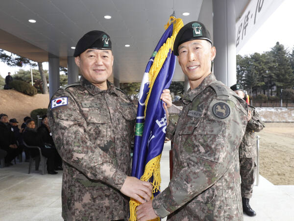 한기성 1군단장(왼쪽)이 최원석 신임 9사단장에게 사단기를 전달하고 있다. 9사단 제공