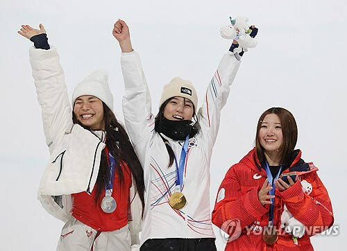 시상대에서 활짝 웃고 있는 최가온(가운데)과 클로이 김(왼쪽). 연합뉴스