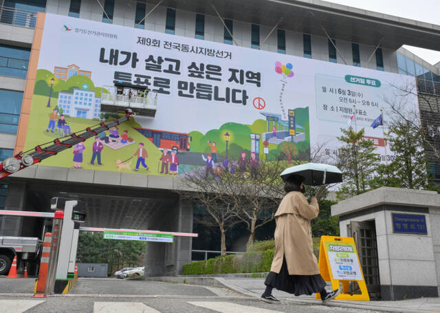 제9회 전국동시지방선거를 55일 앞둔 9일 오전 수원특례시 영통구 경기도선거관리위원회에서 관계자들이 투표 홍보 현수막을 설치하고 있다. 윤원규기자