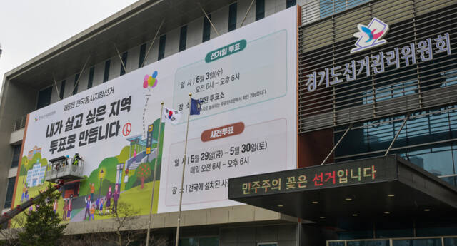 제9회 전국동시지방선거를 55일 앞둔 9일 오전 수원특례시 영통구 경기도선거관리위원회에서 관계자들이 투표 홍보 현수막을 설치하고 있다. 윤원규기자