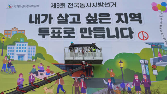 제9회 전국동시지방선거를 55일 앞둔 9일 오전 수원특례시 영통구 경기도선거관리위원회에서 관계자들이 투표 홍보 현수막을 설치하고 있다. 윤원규기자