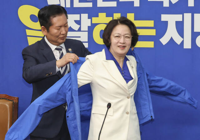 더불어민주당 정청래 대표가 13일 국회에서 최고위원회의에 앞서 열린 추미애 경기도 지사 후보 환영식에서 추 후보에게 선거용 점퍼를 입혀주고 있다. 연합뉴스
