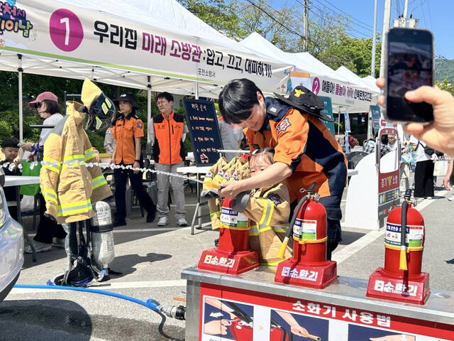 포천소방서 대원들이 봄철 축제장을 찾은 어린이들을 대상으로 ‘우리집 미래소방관 입고, 끄고, 대비하기’ 소방안전체험을 진행하고 있다. 포천소방서 제공