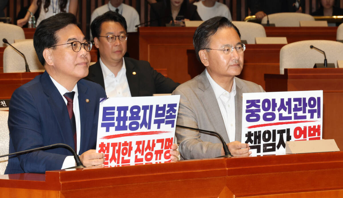 국민의힘 송언석 원내대표와 유상범 원내운영수석부대표가 4일 국회에서 열린 긴급 의원총회에서 투표용지 부족 사태와 관련한 중앙선관위 규탄 손팻말을 들고 있다. 연합뉴스