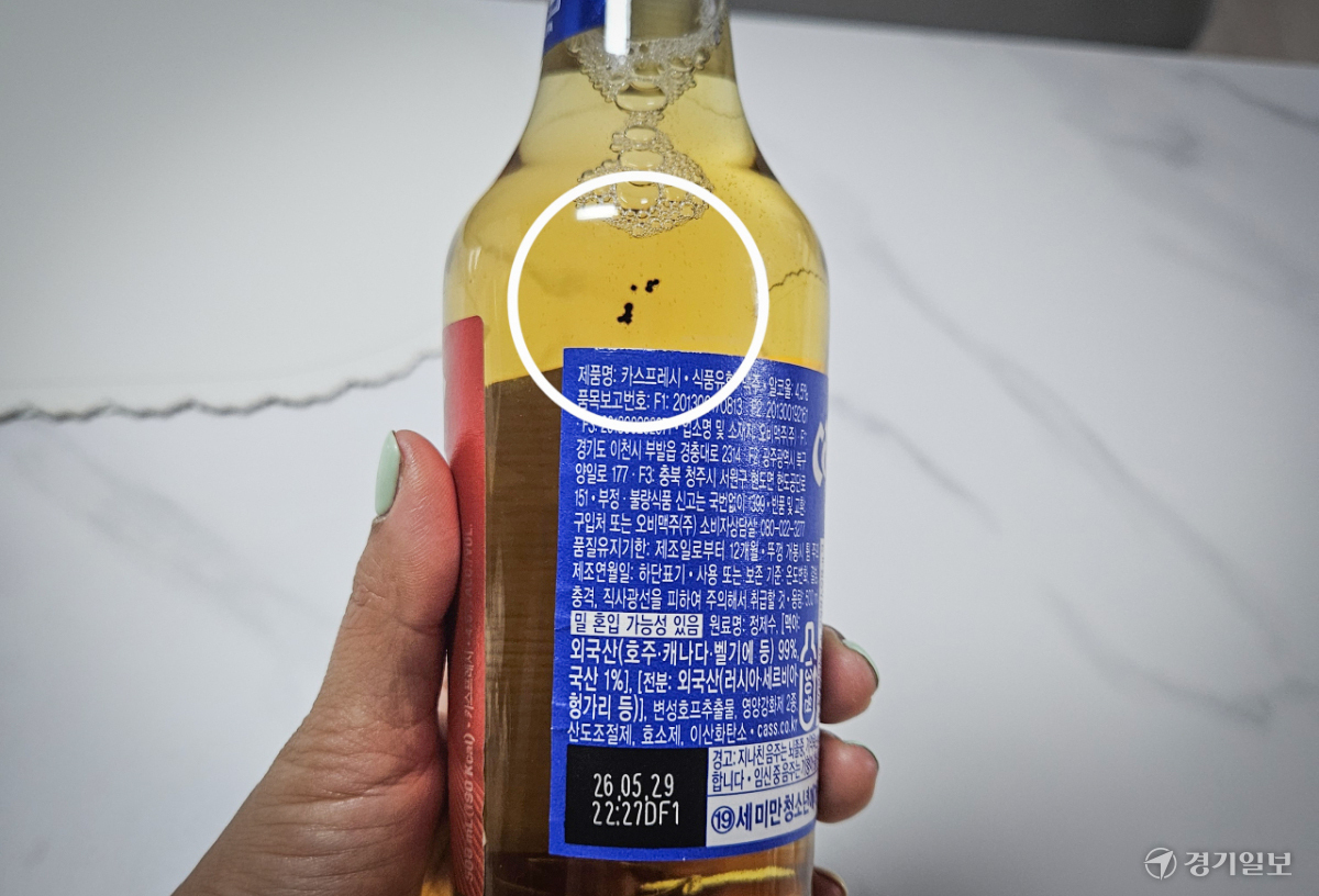 따지도 않은 OB맥주 병 안에 검은 이물질이 둥둥... 원인 규명 요구